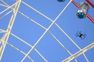 Drone take off from land and flying for take photo front of ferris wheel