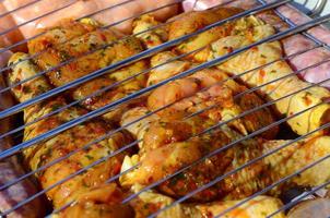 Piernas de pollo marinadas en parrilla de campo de carbón de barbacoa caliente foto