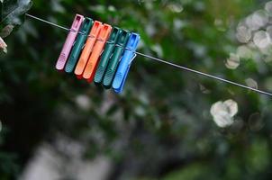 Clothespins on a rope hanging outside house and apple tree photo