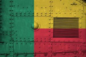 Benin flag depicted on side part of military armored tank closeup. Army forces conceptual background photo