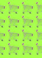 Shopping addiction, shopping lover or shopaholic concept. Many small empty shopping carts perform a pattern on a pastel colored paper background. Flat lay composition, top view photo