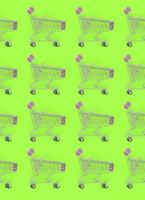 Shopping addiction, shopping lover or shopaholic concept. Many small empty shopping carts perform a pattern on a pastel colored paper background. Flat lay composition, top view photo