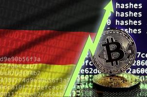 bandera alemana y flecha verde ascendente en la pantalla de minería bitcoin y dos bitcoins dorados físicos foto