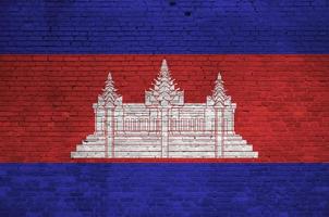bandera de camboya representada en colores de pintura en la pared de ladrillo antiguo. banner texturizado sobre fondo de mampostería de pared de ladrillo grande foto