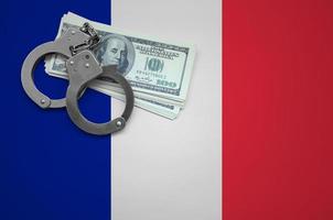 bandera de francia con esposas y un paquete de dólares. el concepto de violar la ley y los delitos de los ladrones foto
