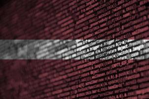 Latvia flag  is depicted on the screen with the program code. The concept of modern technology and site development photo