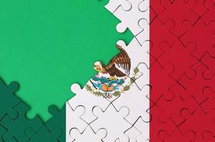 Mexico flag  is depicted on a completed jigsaw puzzle with free green copy space on the left side photo