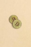 Two golden bitcoins lies on a blanket made of soft and fluffy light orange fleece fabric. Physical visualization of virtual crypto currency photo