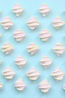 Colorful marshmallow laid out on blue paper background. pastel creative textured pattern. minimal photo
