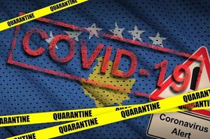 Kosovo flag and Covid-19 quarantine yellow tape with red stamp. Coronavirus or 2019-nCov virus photo
