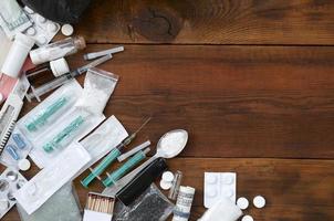 A lot of narcotic substances and devices for the preparation of drugs lie on an old wooden table photo