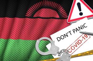 Malawi flag and police handcuffs with inscription Don't panic on white paper. Coronavirus or 2019-nCov virus concept photo