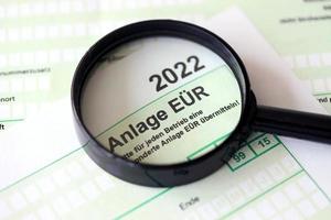 Anlage EUR - German 2022 Profit and Loss Statement and magnifying glass close up. The concept of taxation and accountant paperwork Germany photo