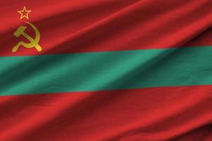 Transnistria flag with big folds waving close up under the studio light indoors. The official symbols and colors in banner photo