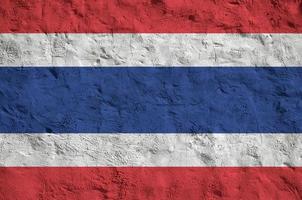 Thailand flag depicted in bright paint colors on old relief plastering wall. Textured banner on rough background photo