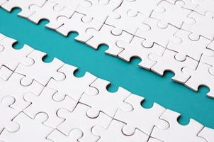The blue path is laid on the platform of a white folded jigsaw puzzle. Texture image with copy space for text photo
