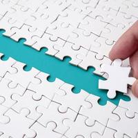 The human hand paves the way to the surface of the jigsaw puzzle, forming a blue space. The concept of overcoming the difficulties on the way to success photo