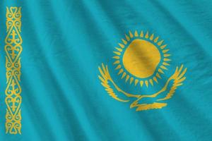 Kazakhstan flag with big folds waving close up under the studio light indoors. The official symbols and colors in banner photo