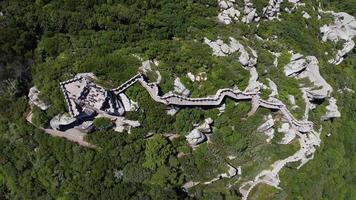 Aerial drone view of  Moorish Castle  Sintra, Portugal during a sunny day. Unesco World Heritage. Historic visits. Holidays and summer vacation tourism. Sightseeing video