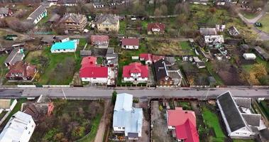 antenne visie van groen dorp met huizen, hoeve, schuren, kassen en grind weg video