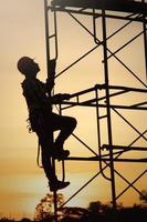 Silhouette young construction worker working on construction during sunset background job photo