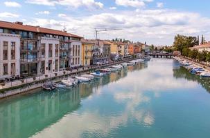 Peschiera del Garda, Verona, Italy - 22 September 2022 Beautiful cityscape with houses and boats at Canale di mezzo at Peschiera, Lago del Garda photo