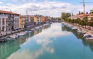 Peschiera del Garda, Verona, Italy - 22 September 2022 Beautiful cityscape with houses and boats at Canale di mezzo at Peschiera, Lago del Garda photo