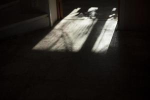 Light from window on floor. Shadow from window frame. Light in room. photo