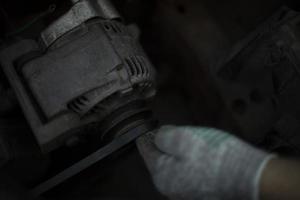 Engine repair. Man twists part in car. Promotion of transport. photo