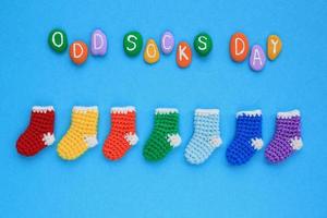 Odd socks day lettering and mismatched colourful socks on blue background. Social school bullying concept. Lost lonely sock. Diversity and inclusion. Top view flatlay idea of poster, banner, advertise photo