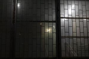 Grille on window at night. Window with lattice. Entrance to entrance in evening. photo