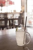 Glass of frozen lemonade with lemon slice on the wooden table photo