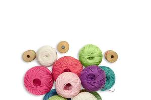 Balls of wool yarn with wooden bobbin with threads on white isolated background. Concept of knitting, sewing. Copy space photo