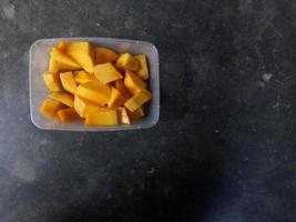 rebanadas de mango servidas en un recipiente de plástico foto