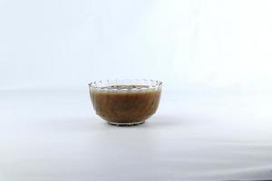 A bowl of Green Bean Porridge isolated on a white background. a typical Indonesian dessert made from green beans cooked with coconut milk and palm sugar. photo