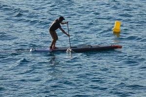 swimmer on vacation paddle surfing in the mediterranean sea photo