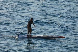 swimmer on vacation paddle surfing in the mediterranean sea photo