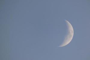 luna creciente bajo el cielo azul foto