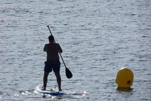 swimmer on vacation paddle surfing in the mediterranean sea photo