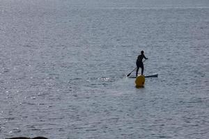 swimmer on vacation paddle surfing in the mediterranean sea photo