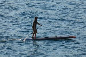 swimmer on vacation paddle surfing in the mediterranean sea photo