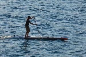 swimmer on vacation paddle surfing in the mediterranean sea photo