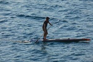 swimmer on vacation paddle surfing in the mediterranean sea photo