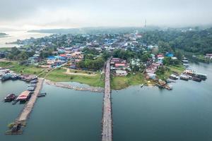 Traditional Mon village in morning foggy and wooden Mon bridge in the dam at Sangkhlaburi photo