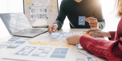 grupo de lluvia de ideas de concepto de trabajo de personas. lluvia de ideas del equipo de negocios. investigación del plan de marketing. papeleo en la mesa, computadora portátil y teléfono móvil. foto