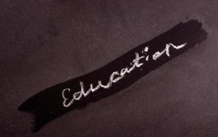 Hand written word EDUCATION with white chalk on blackboard photo