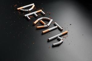 The inscription DEATH from cigarettes on a black background. Stop smoking. The concept of smoking kills. Motivation inscription to quit smoking, unhealthy habit. photo