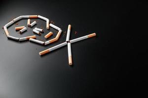 cráneo de cigarrillos sobre un fondo negro. el concepto de fumar mata. hacia el concepto de fumar como un hábito mortal, venenos de nicotina, cáncer por fumar, enfermedad, dejar de fumar. foto
