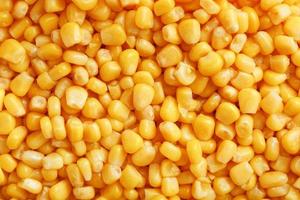Golden canned corn, as distributed on a plane background and texture of popcorn. Before watching a movie top view. Close-up photo