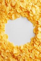 Golden cornflakes on full frame with empty white space. Healthy breakfast photo